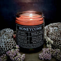 Honeycomb candle with a label surrounded by honeycomb and flowers on a dark background