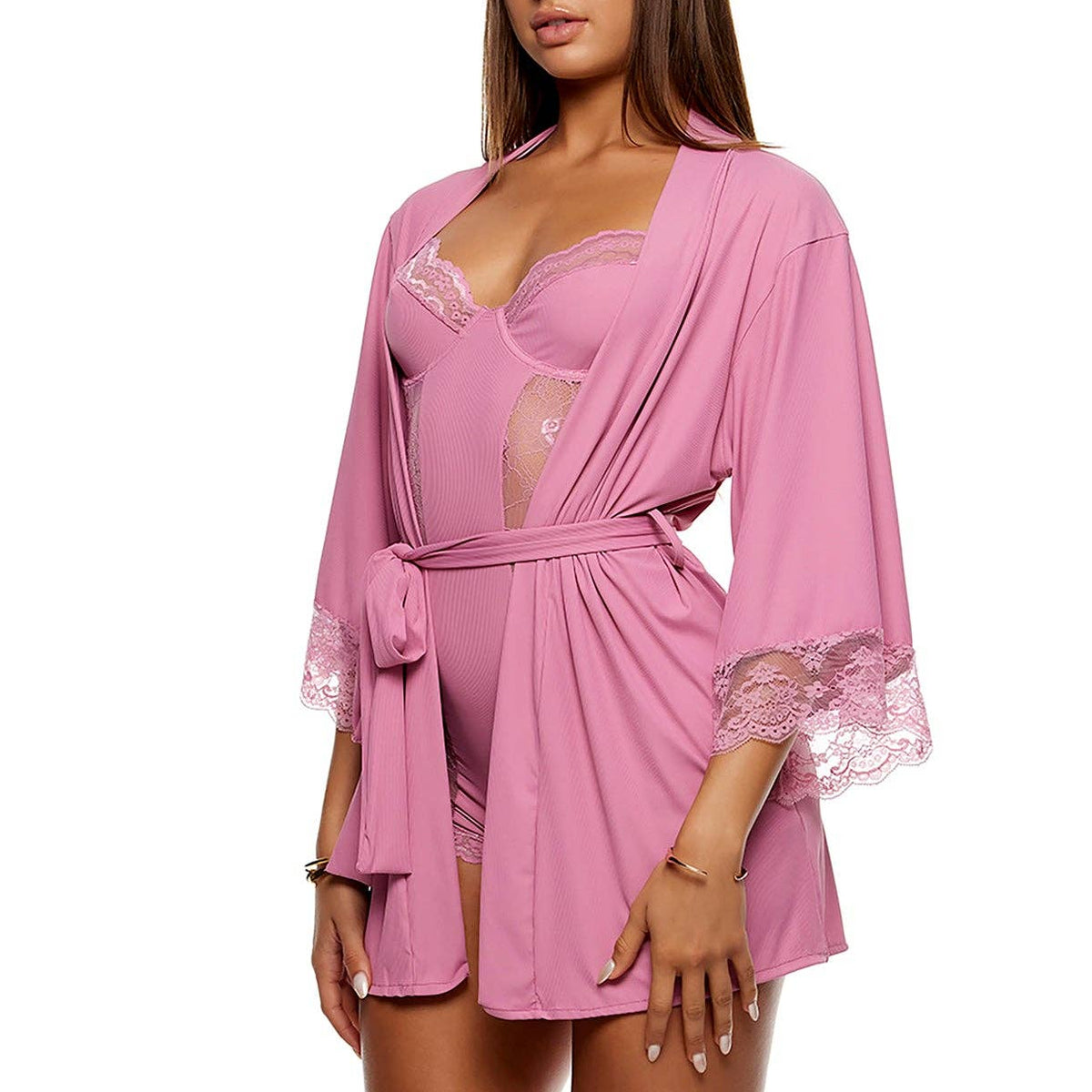 A woman modeling a pink robe-style lingerie piece with lace trim and sheer panels, paired with clear high-heel sandals, against a plain white background.