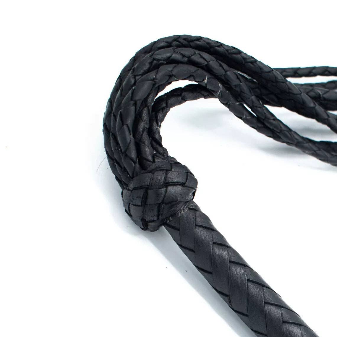 A close up of the neat braids around the handle, where it meets the tails of the flogger.