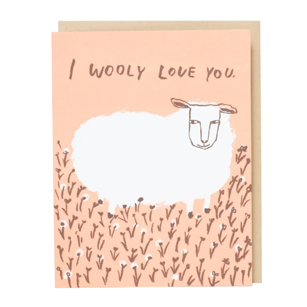 Greeting card with a sheep illustration and 'I woolly love you' text on a pink background