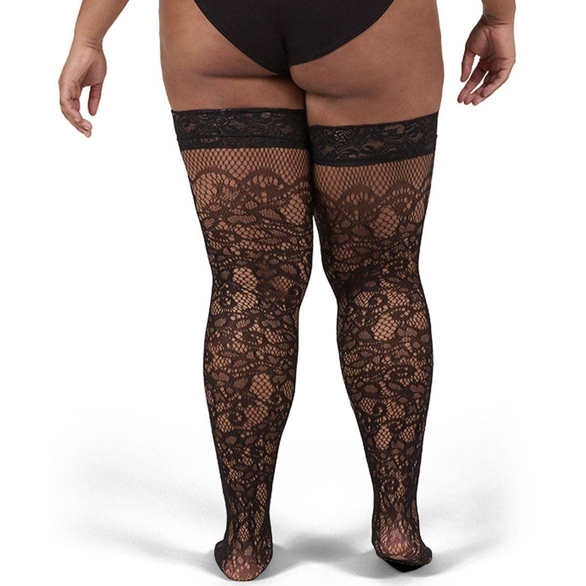 A model from the back wearing black lace thigh-high stockings and a black bodysuit against a plain white background.