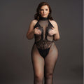 Woman wearing a black lace bodysuit and fishnet stockings against a gray background