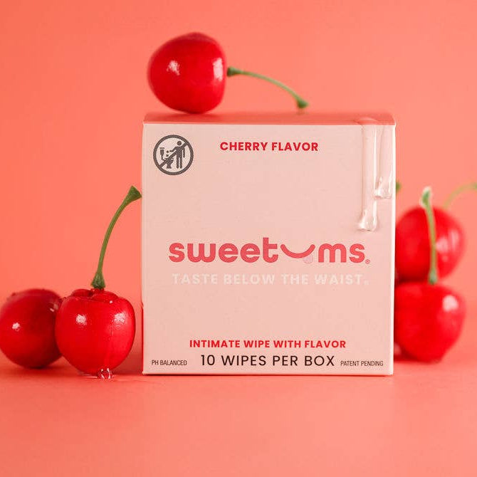 Box of 'sweetums' cherry-flavored intimate wipes with cherries on a pink background