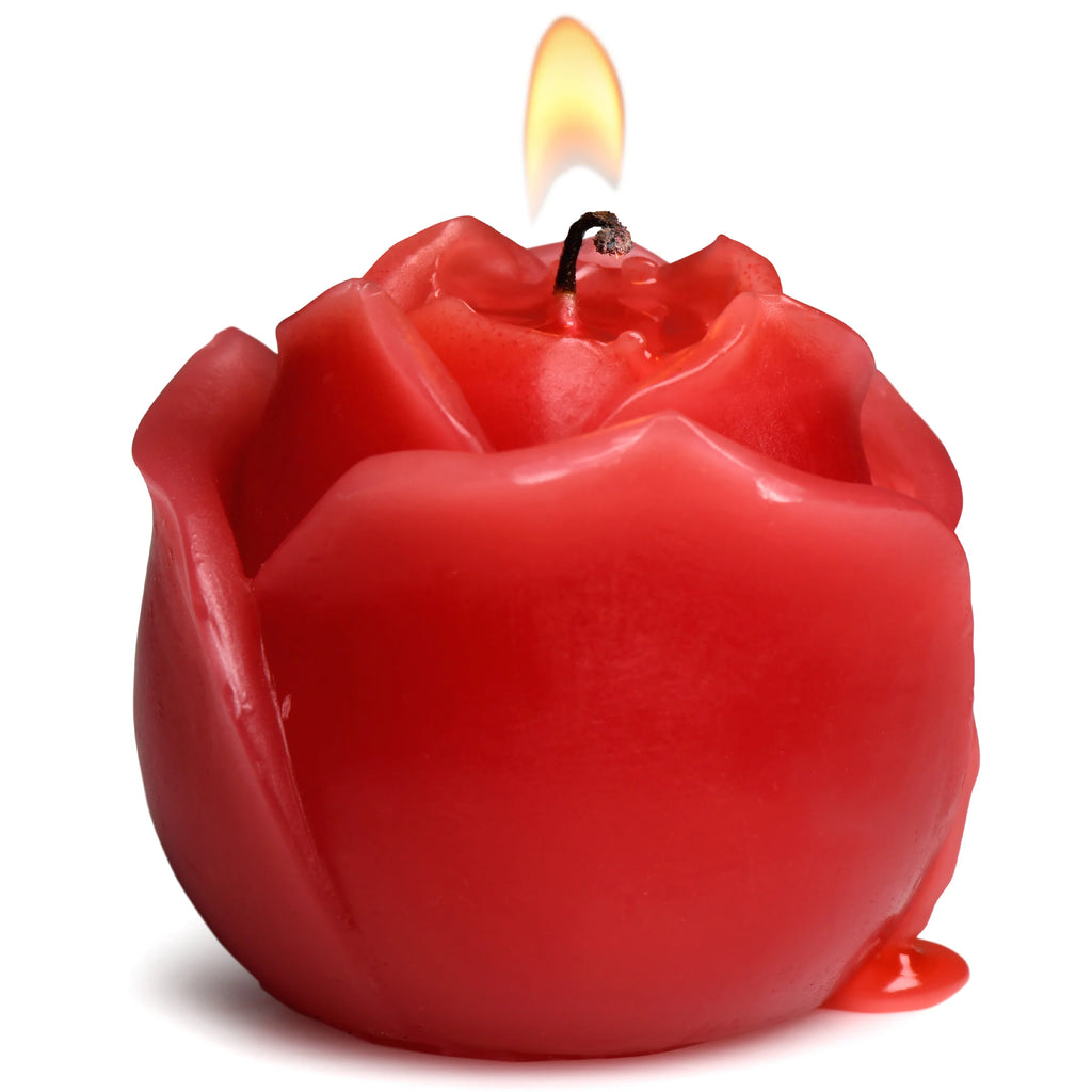 Red rose-shaped candle with a lit wick on a white background