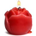 Red rose-shaped candle with a lit wick on a white background