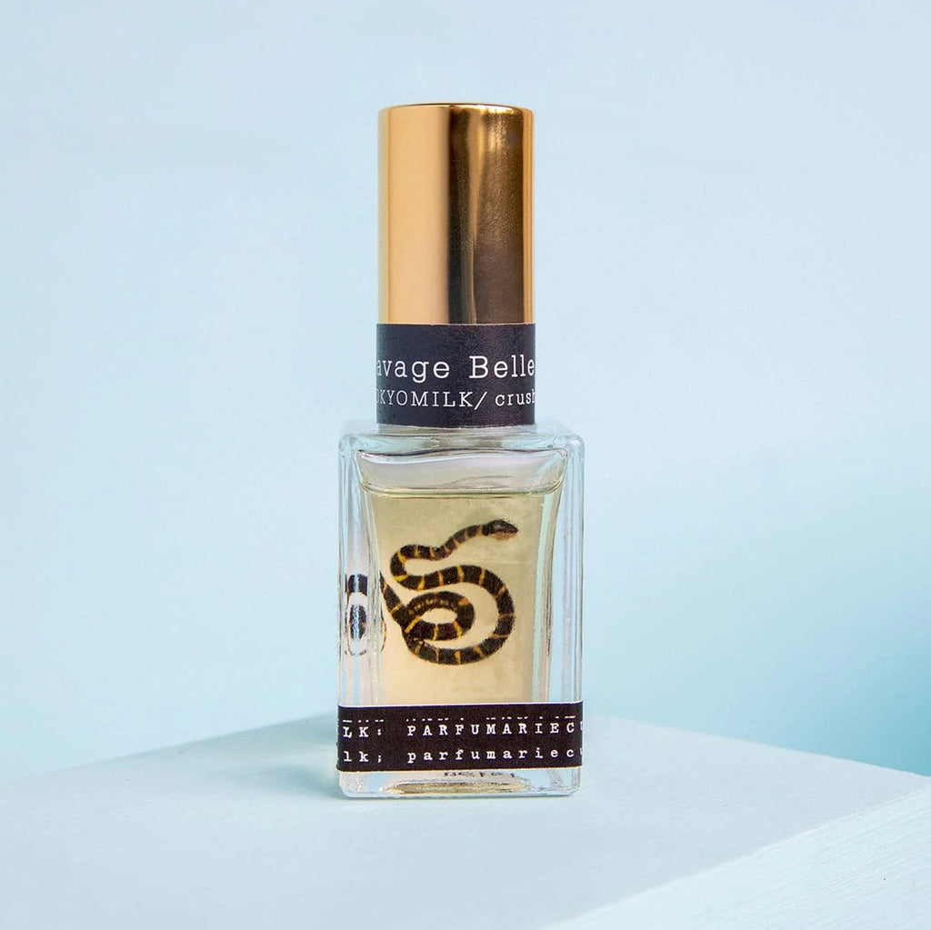 Perfume bottle with gold cap and black label on a light blue background
