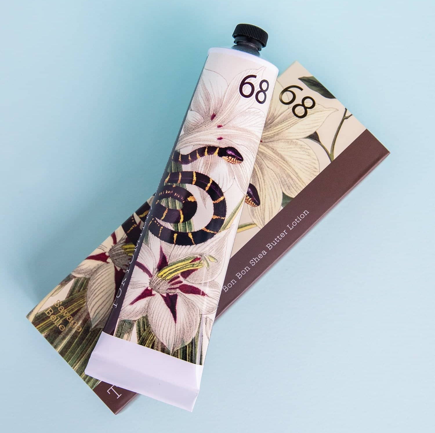 Hand cream tube with floral design on a light blue background