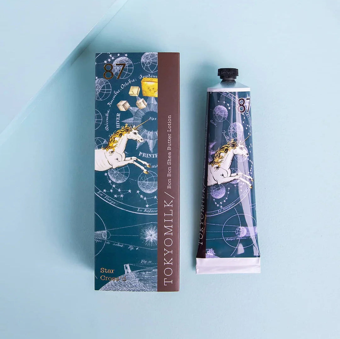 A tube of shea butter lotion adorned with a unicorn adrift in a blue galaxy.