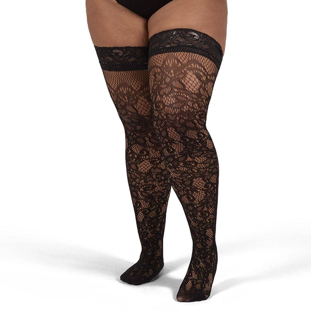 Black lace thigh-high stockings worn by a model in a black bodysuit, shown from the waist down on a white studio background.