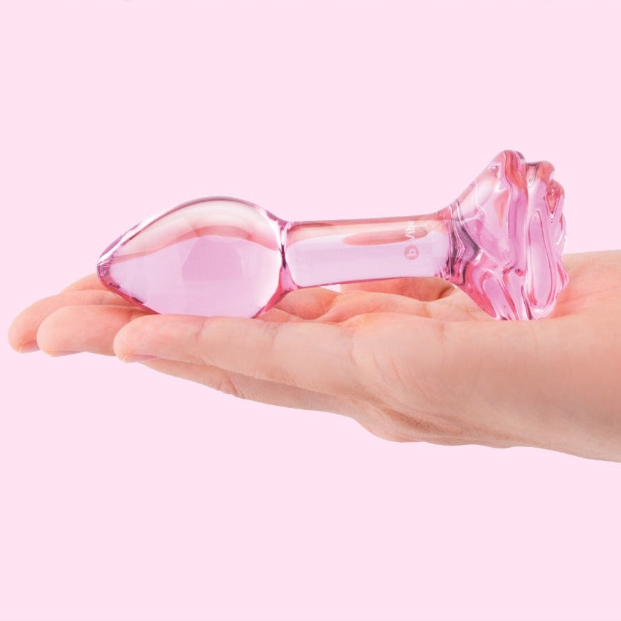 Pink glass product held in a hand with 'Body-Safe Glass - Durable & non-porous' text on a pink background
