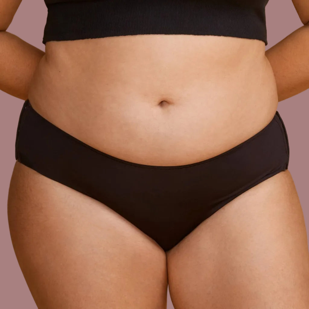 A plus-size model wearing a solid black panties that do not bind into her skin.