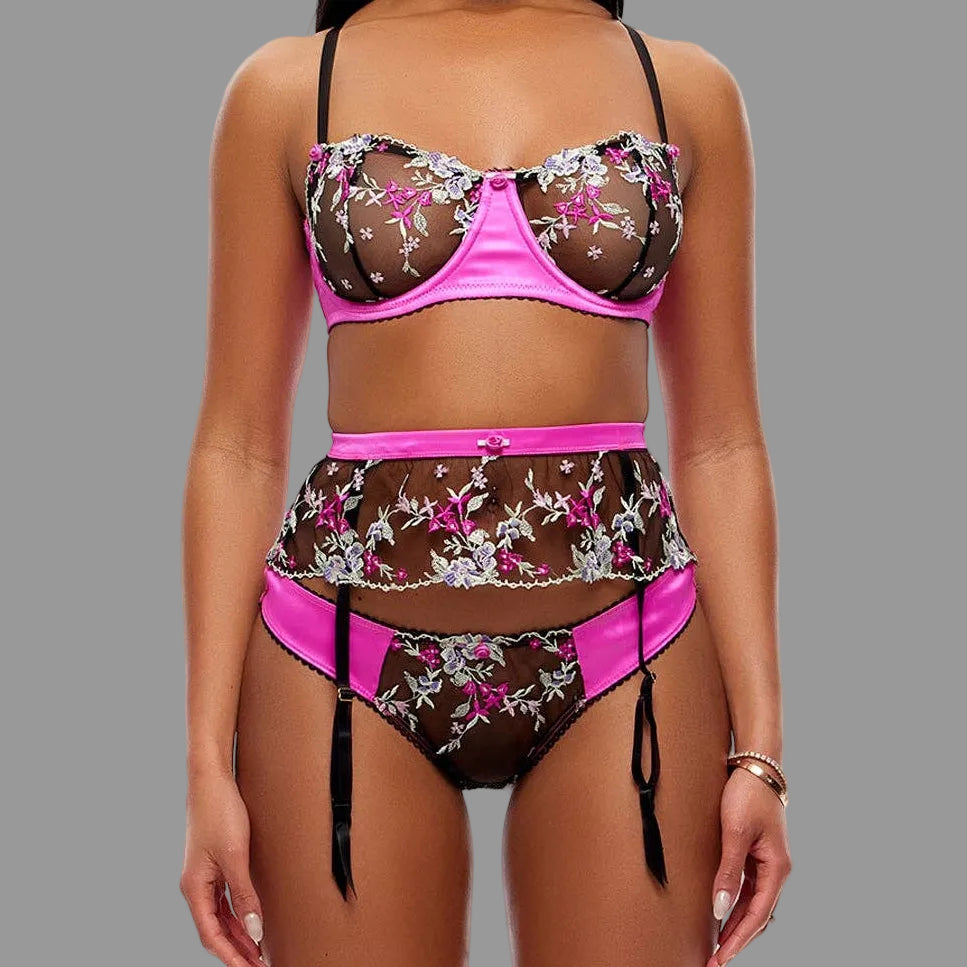 Woman wearing a floral bra and thong set with pink accents on a white background