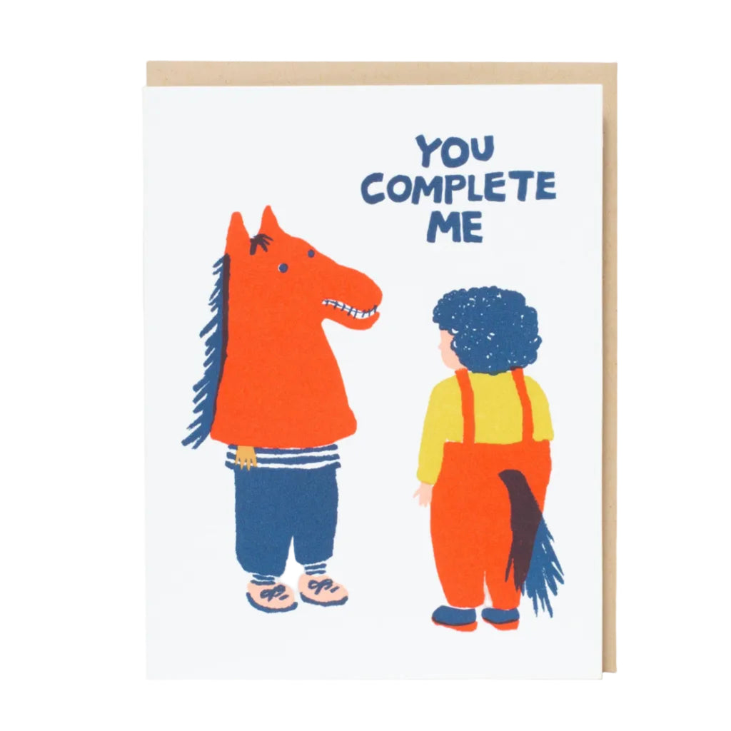 Illustration of a person wearing horse head and another a person wearing the body portion of a horse costume with 'You Complete Me' text on a white background