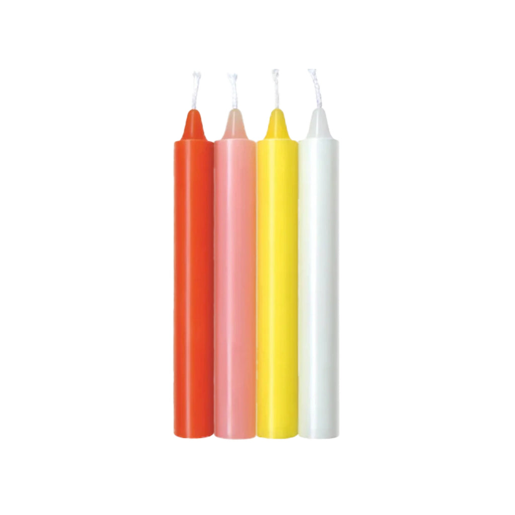 Four pastel drip candles in orange, pink, yellow, and white, standing upright on a plain white background.