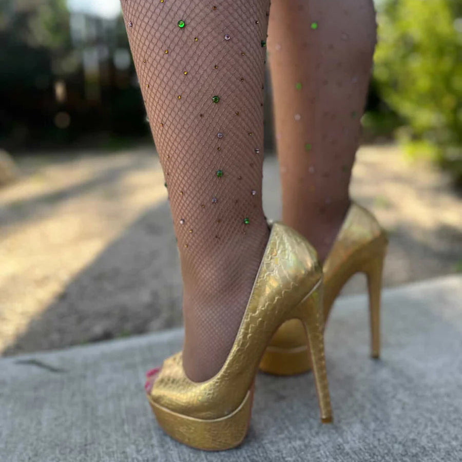 Gold high-heeled shoes worn with fishnet stockings outdoors.