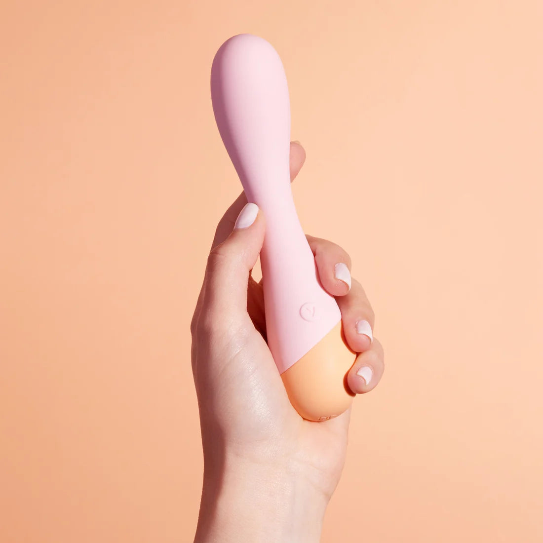 A hand holding a slightly curved G spot toy. The toy is a bit longer than the feminine hand holding it.