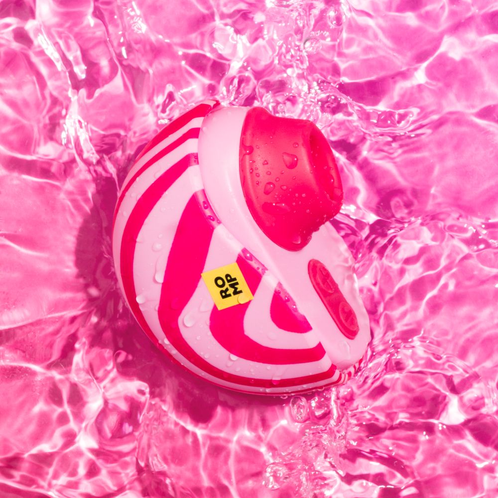 Pink and red striped sex toy floating in  water.