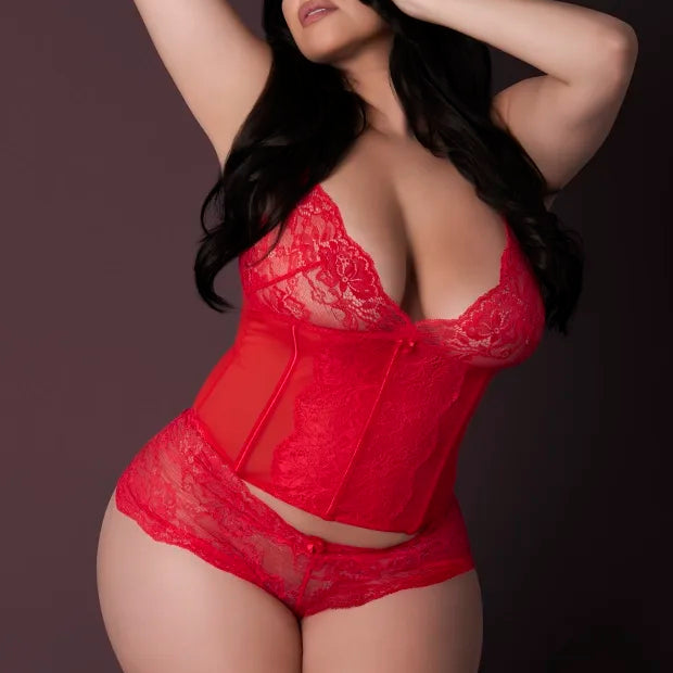 Woman wearing a red lace lingerie set against a dark background