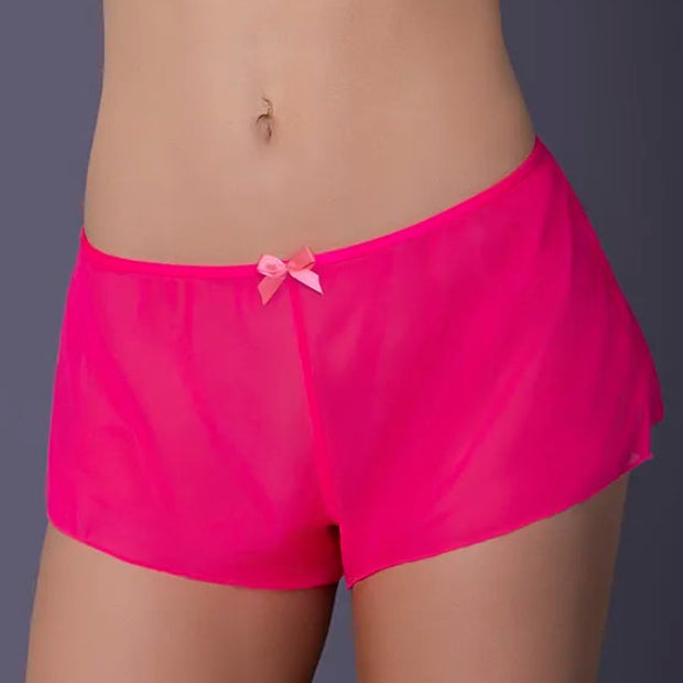 Person wearing bright pink shorts with a white top on a dark background